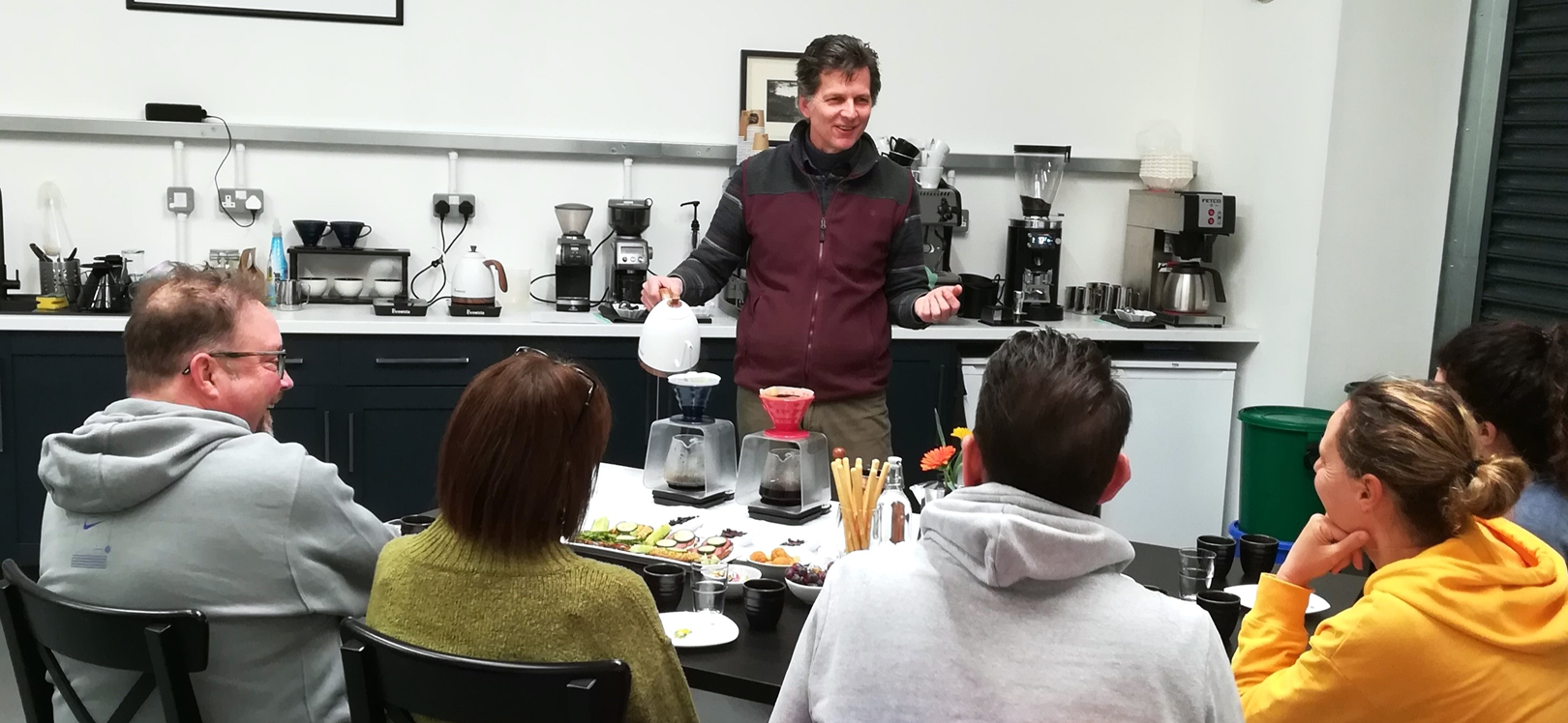 A man serving coffee to a group of people