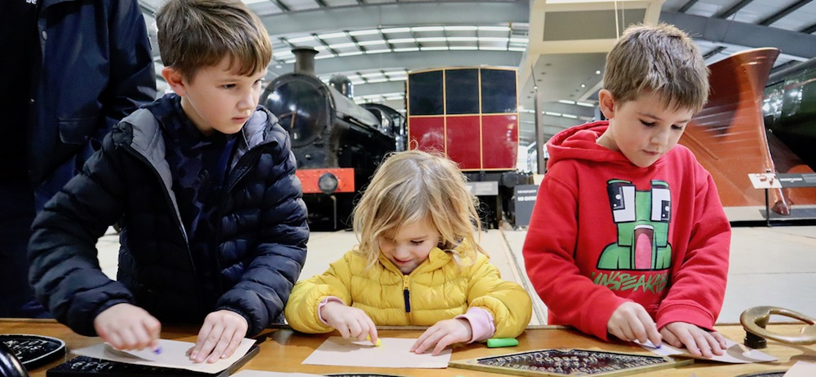 Threee children taking part in activities at Locomotion