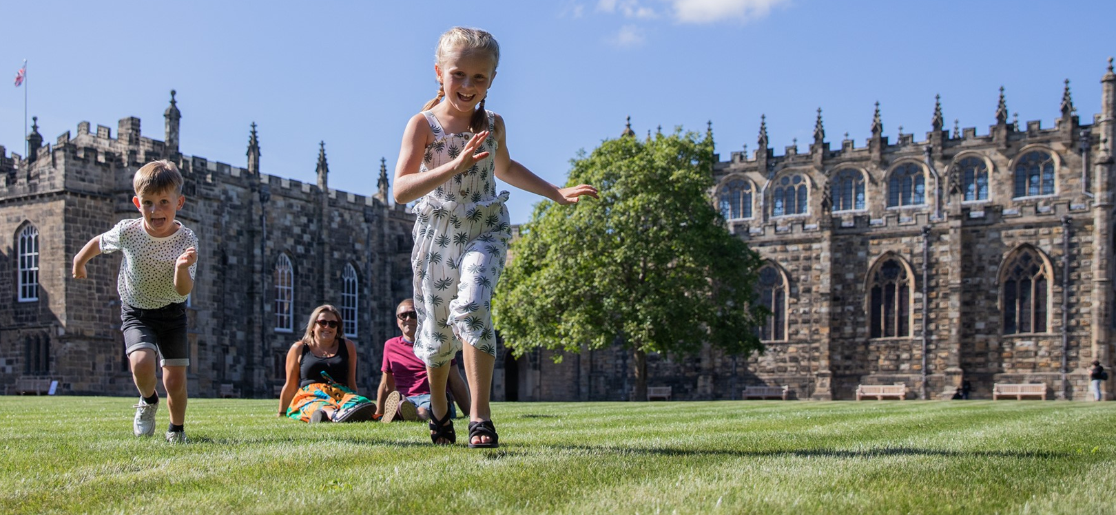 A family playing outside of Auckland Castle