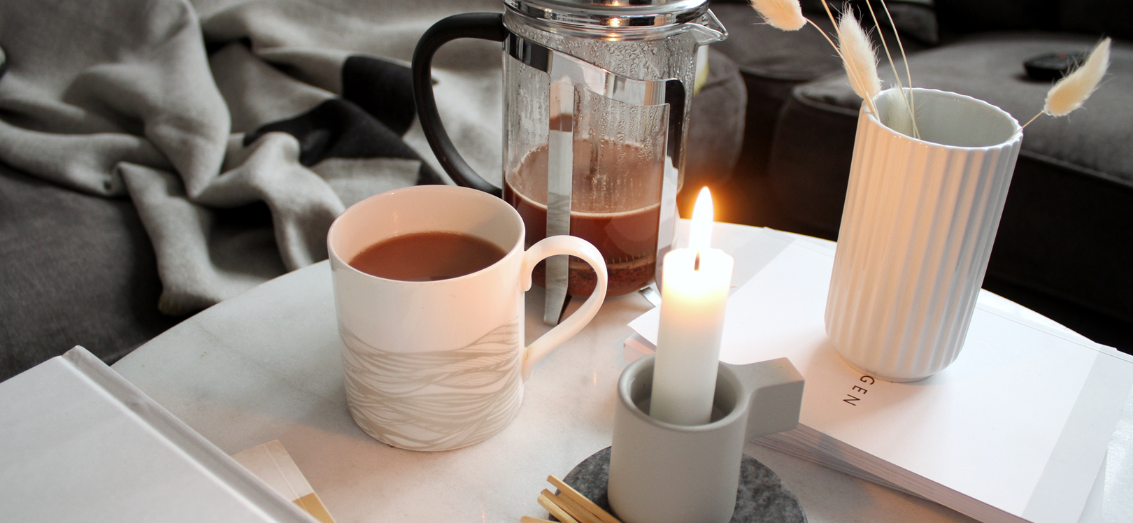A cup of hot chocolate next to a candle