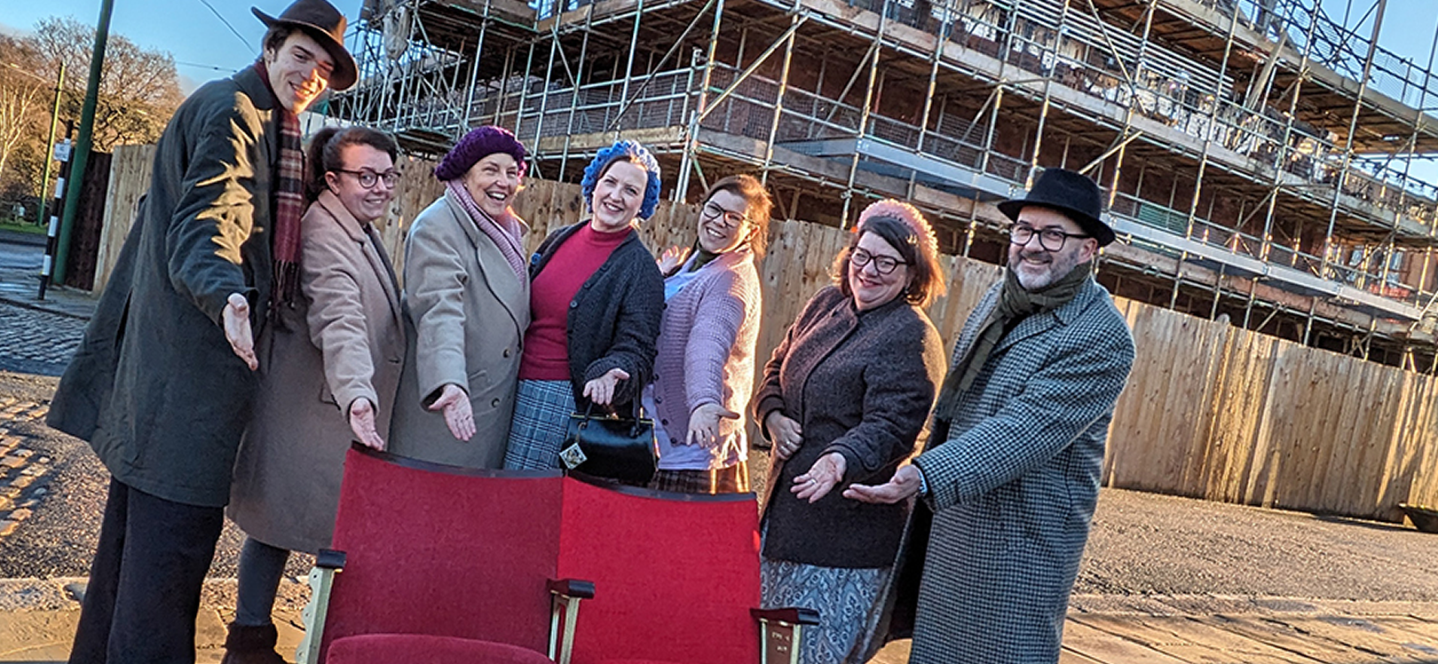 People at Beamish Museum with a cinema seat in front of them