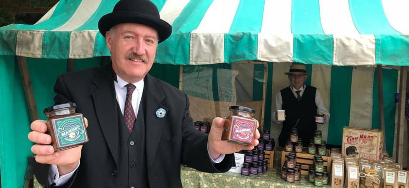 A man holding some bottles at a market in Beamish Museum