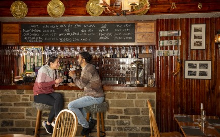 Two people sat at a bar at The Rose and Crown pub