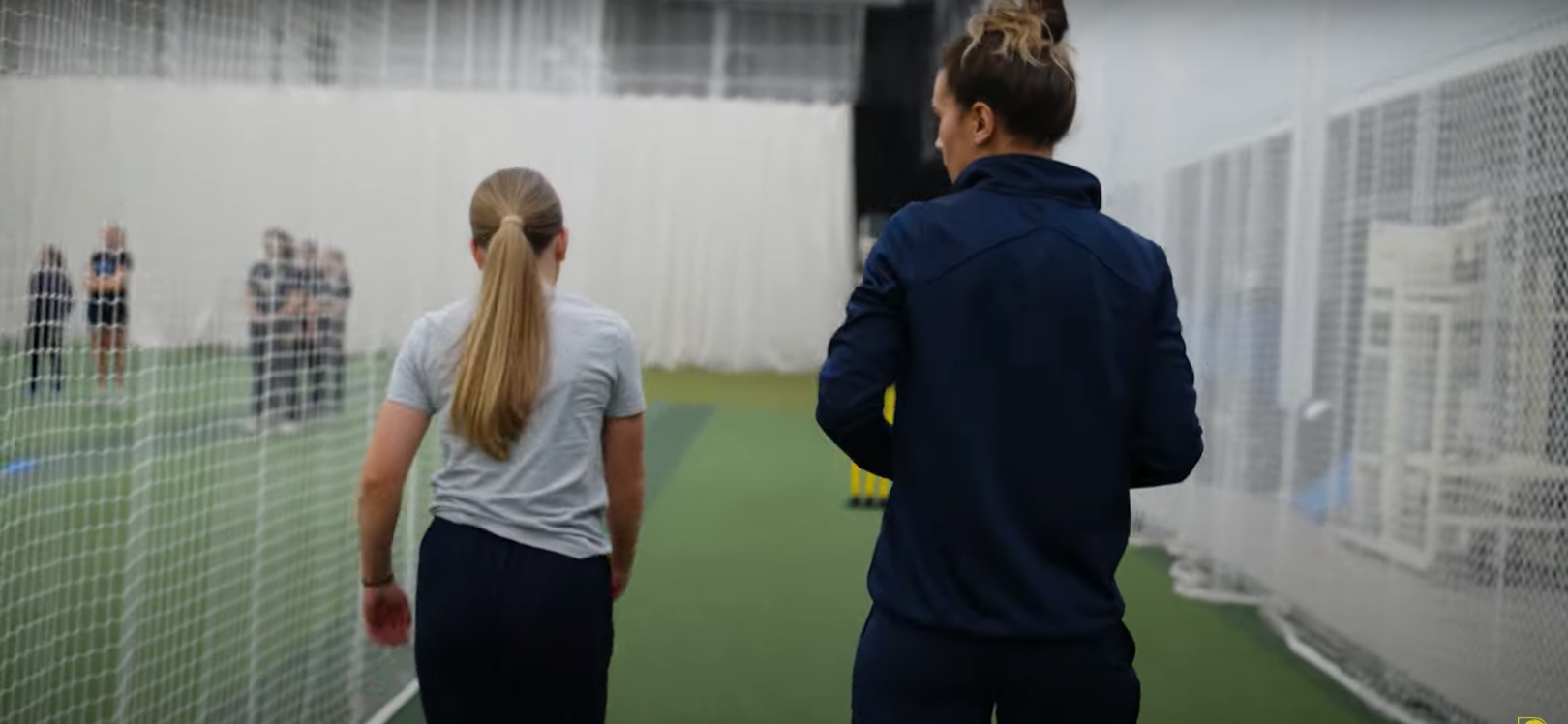 Two women playing cricket