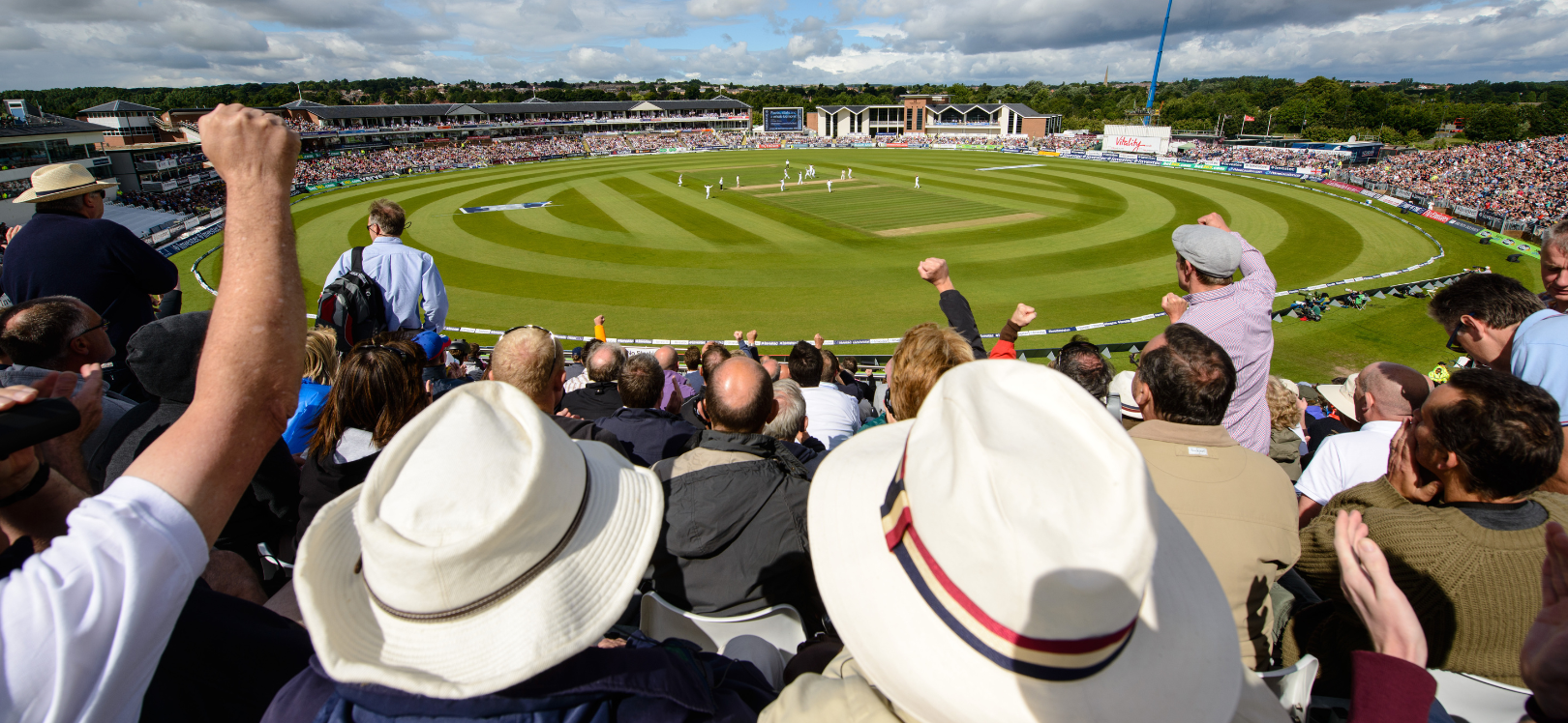 crowd sitting and cheering a cricket match at Durham Riverside Stadium.