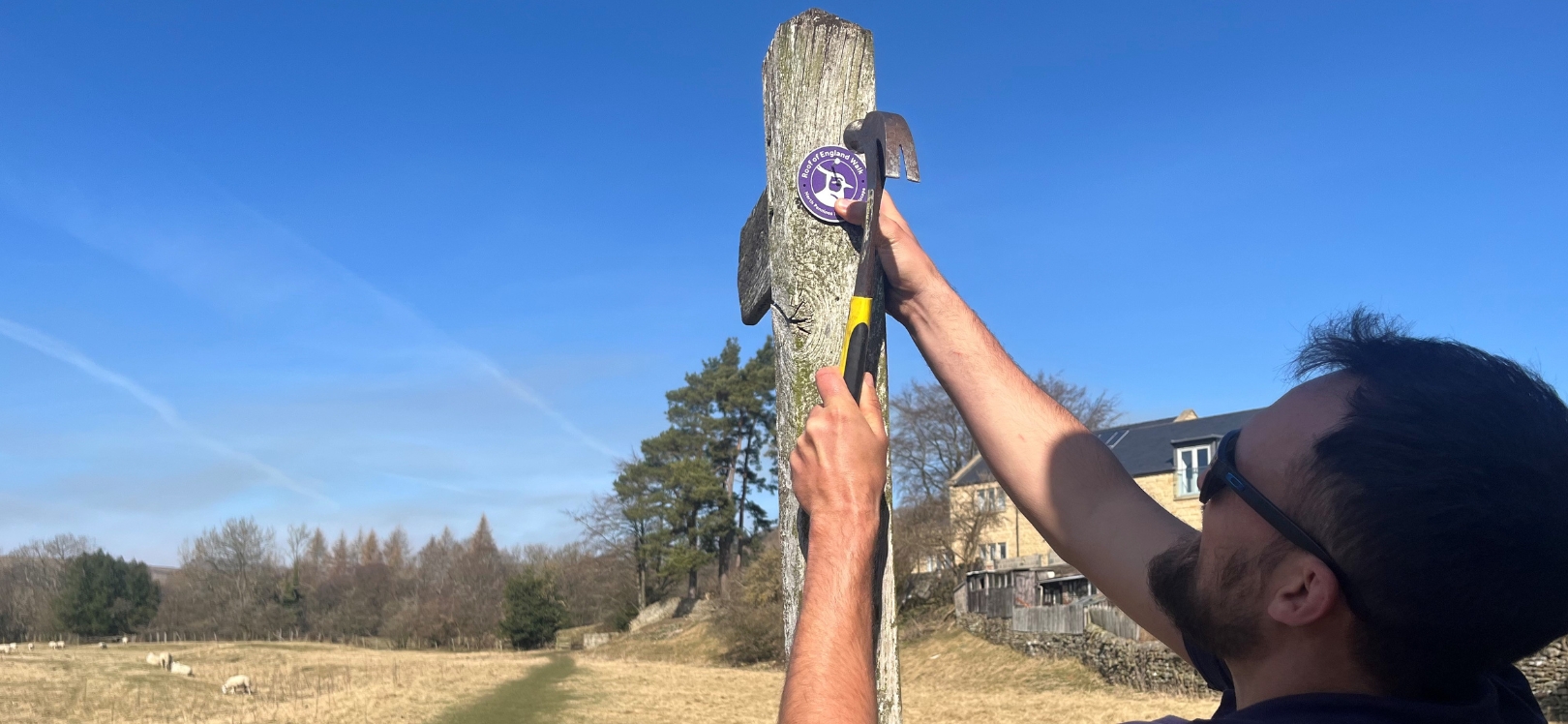 A man putting a way finder stamp on a post